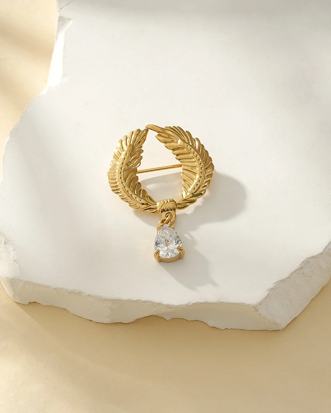 Broche dorée couronne de laurier et goutte de strass